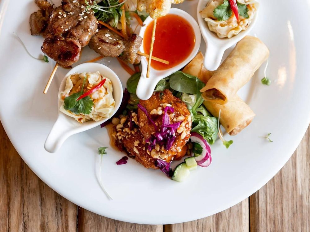 Sharing platter of chicken satay, spring rolls, honey pork and prawn dumplings